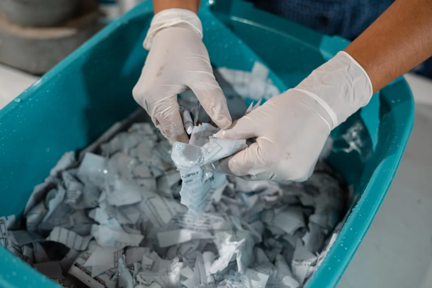 Manos trabajando con papel reciclado en el proceso de ecodiseño